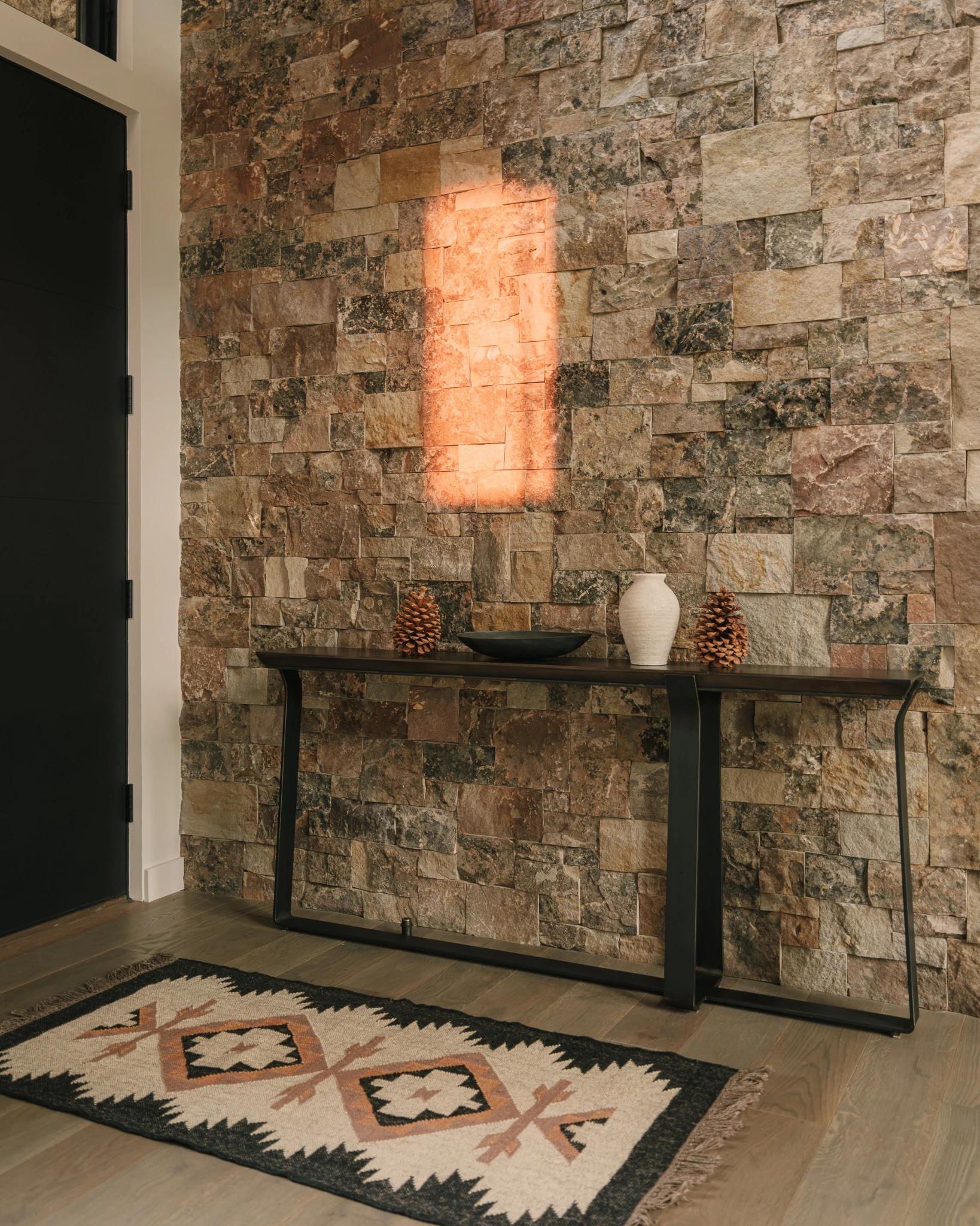 Entry console table against a backlit stone wall — interior design photography Big Sky Montana, Speedwell Cabin